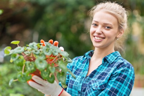 Front view of a gardener working in a Holborn garden, pathway and tools visible